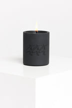 Black candle with a flame on a white background