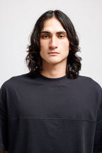 Ink Black | On Model Front Man with long dark hair wearing a black t-shirt against a plain background