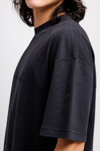 Ink Black | On Model Side Detail Person wearing a black oversized t-shirt on a white background