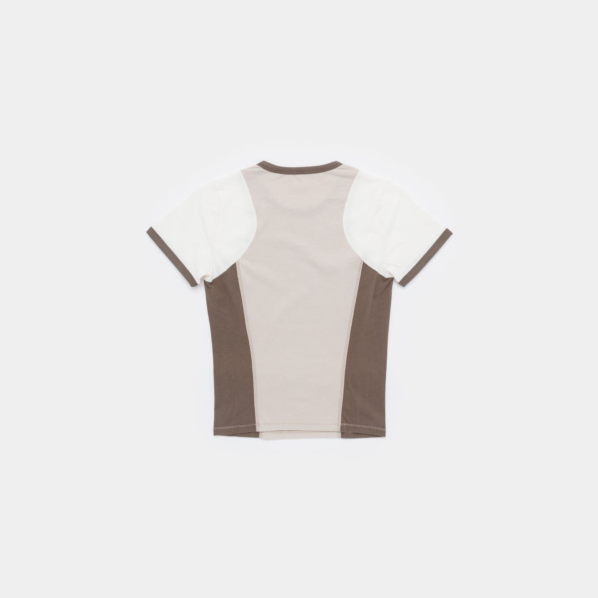 A short-sleeve colorblock t-shirt shown from the back, featuring a light beige center panel, white shoulder panels, and dark brown side panels and collar trim, laid flat against a light gray background.