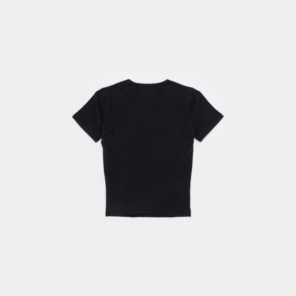 A black short-sleeve crop top with structured shoulder panels and front seam detailing, shown from the back on a light gray background.