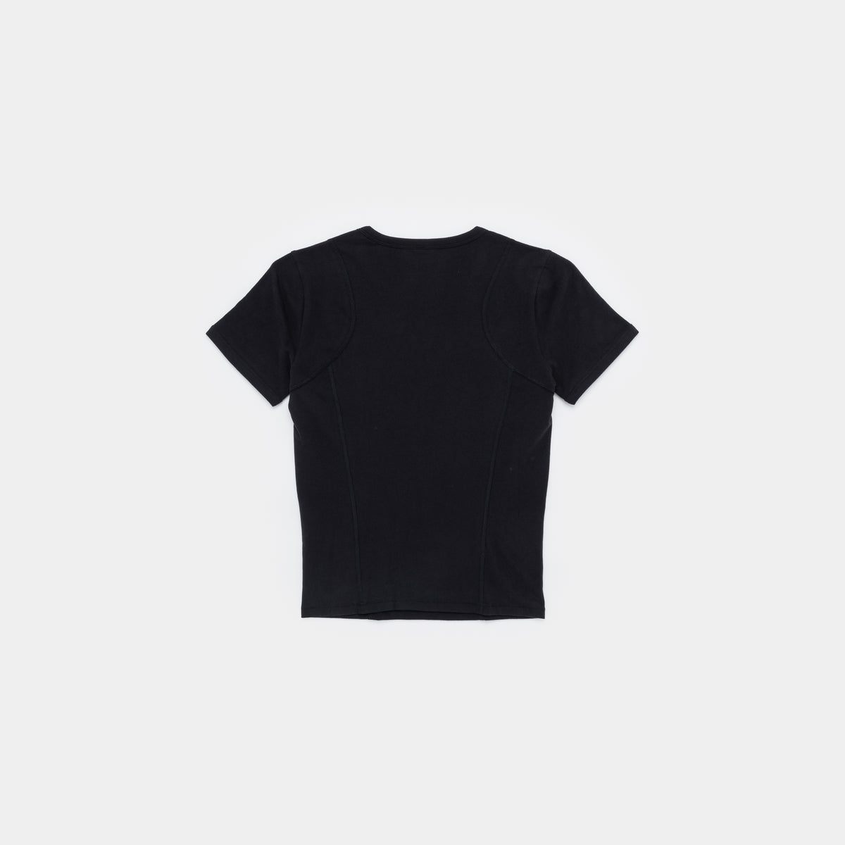 A black short-sleeve crop top with structured shoulder panels and front seam detailing, shown from the back on a light gray background.