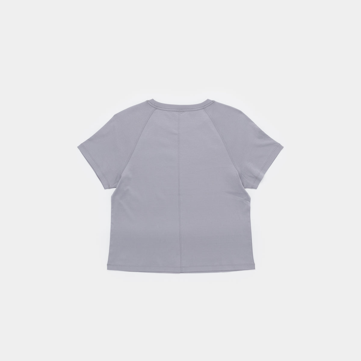 A light gray short-sleeve crop top shown from the back, featuring a central seam and raglan-style shoulder seams, on a solid off-white background.