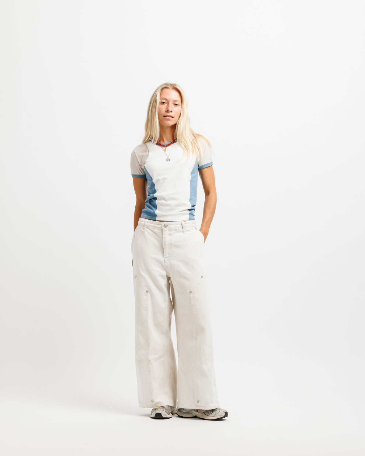 A short-sleeve ringer t-shirt with a white body, light beige shoulder panels