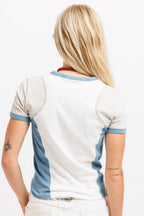 Cougar Milk / Frostbite Blue / Silver Tip | On Model Back A woman viewed from behind wearing a white ringer T-shirt with light blue trim on the collar, sleeve cuffs, and side panels, paired with white pants against a plain white studio background.