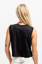 Ink Black | A woman viewed from behind wearing a black sleeveless crop top and white pants against a plain white background.