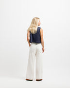 Deepwater Navy | A woman is shown from behind wearing a sleeveless navy top and off-white wide-leg pants, standing against a plain white studio background.