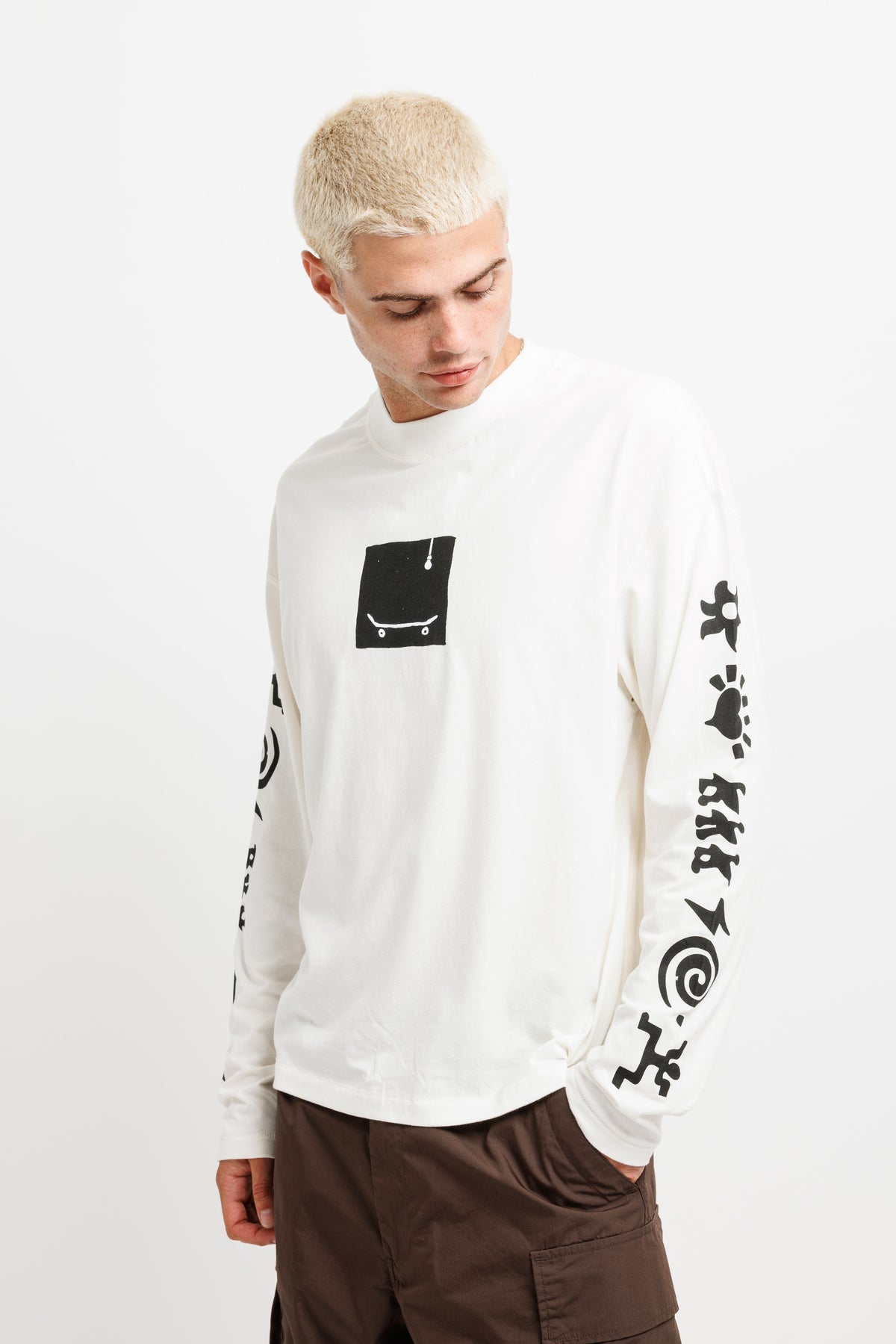White Westbeach long sleeve tee with a black heritage graphic featuring a light bulb, a skateboard board, and classic Westbeach iconography on the sleeves. 