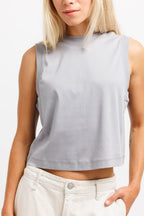 Chiseled Stone | On Model A woman wearing a light gray sleeveless mock-neck crop top and off-white pants, shown from the chin down against a plain white background.