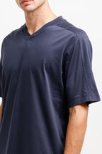 Deepwater Navy | On Model Front Detail A close-up of a man wearing a dark navy blue v-neck t-shirt against a plain white background.