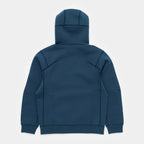 Stillwater Blue | Back A dark teal blue zip-up hoodie shown from the back, featuring integrated paneling and ribbed cuffs and hem, on a light gray background.